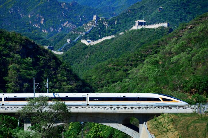 京張高鐵復(fù)興號(hào)動(dòng)車組行駛在長(zhǎng)城腳下。