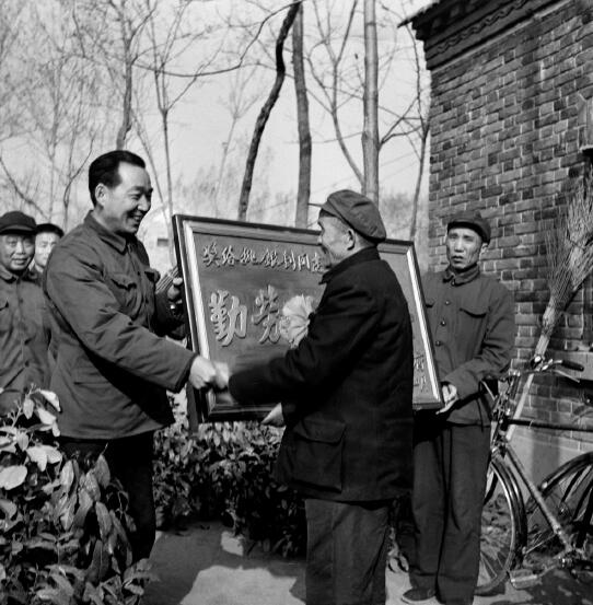 1978年，黨的十一屆三中全會召開，做出了對于當代中國發(fā)展具有歷史性影響的重大決策，開啟了改革開放和集中力量進行社會主義現(xiàn)代化建設的歷史新時期。圖為1982年，時任河南省鄢陵縣縣長吳德榮上門為該縣第一個“萬元戶”頒發(fā)勞動光榮匾。