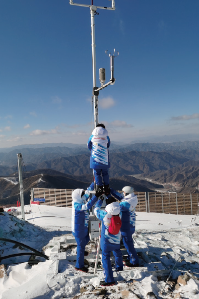 2022年1月25日，延慶賽區(qū)駐場的北京冬奧 會冬殘奧會外圍氣象服務(wù)團隊現(xiàn)場觀測保障人員 正在維護國家高山滑雪中心競速賽道附近的自動 氣象站。